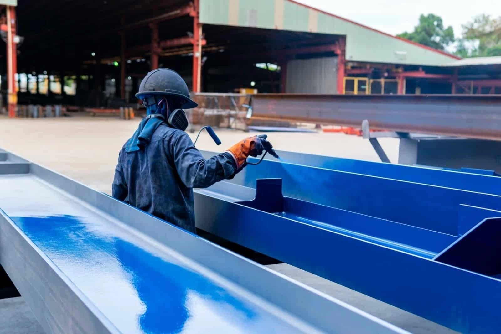 Factory worker applying industrial coating